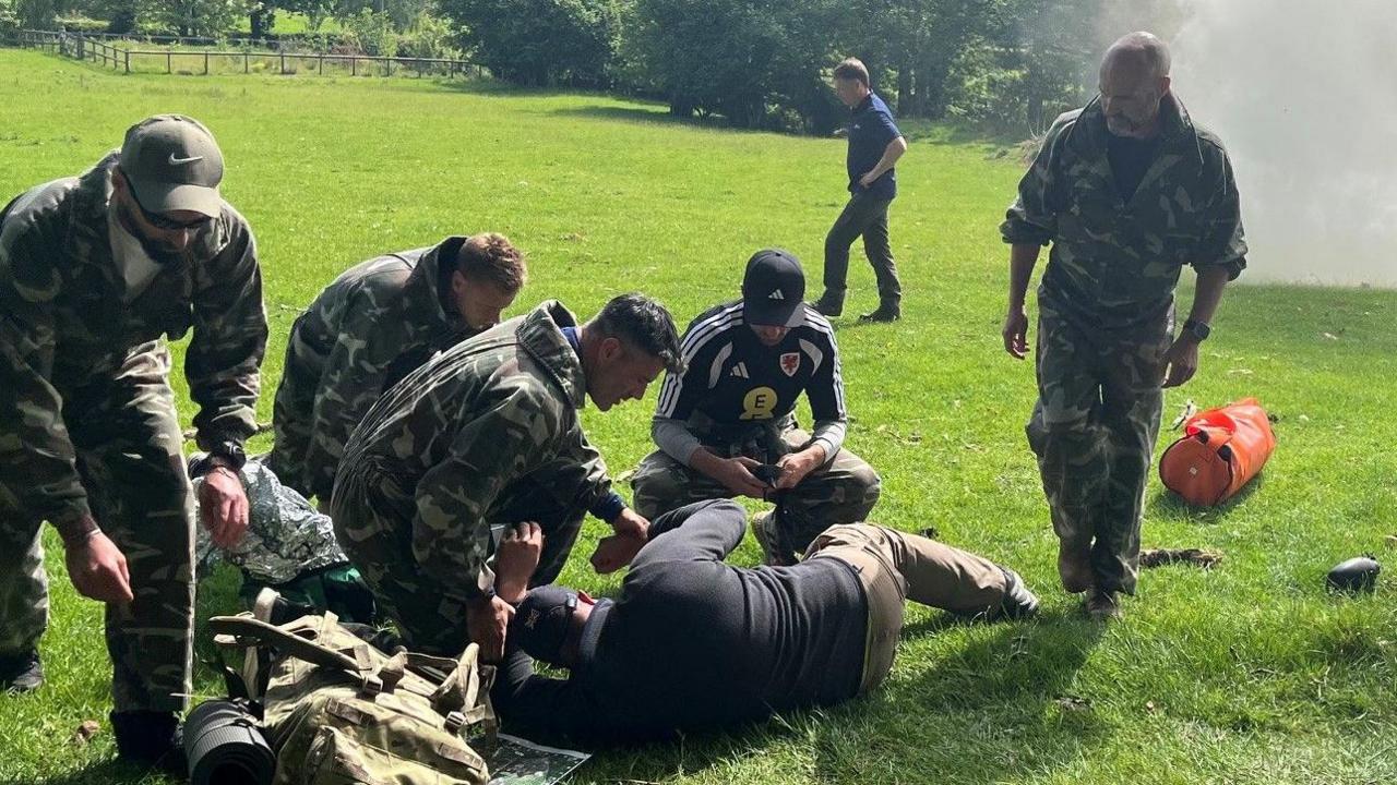 Aaron Ramsey, Willy Caballero, Luke Williams tend to a casualty during a military training exercise