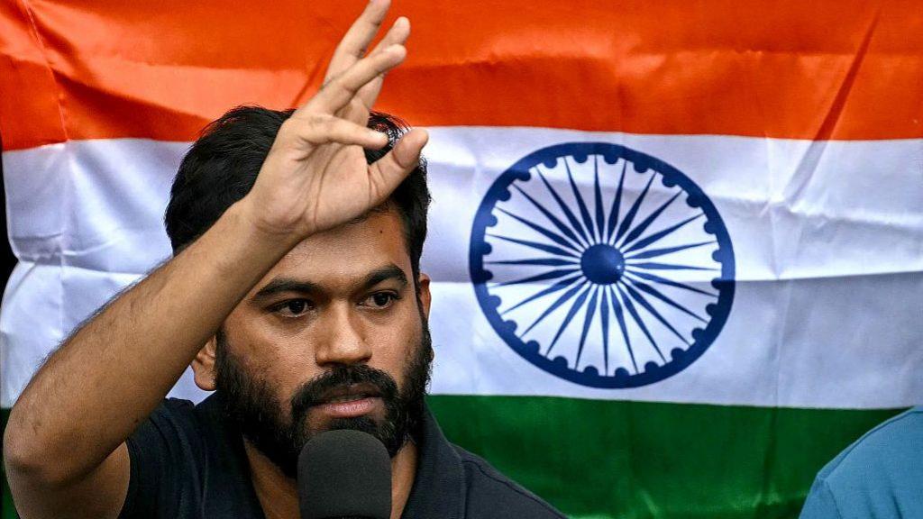 Abhijeet Dipke holds the Indian flag during a press conference