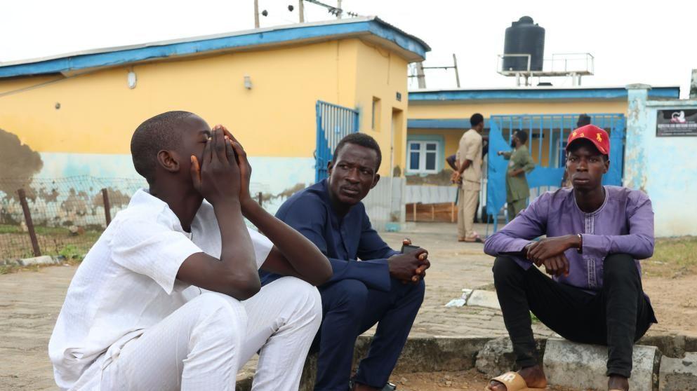 Family members sit outside the General Hospital to reclaim the bodies of their relatives in Minna, Niger State, 18 September