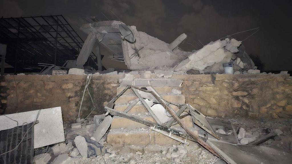 Rubble sits atop a small brick wall and six stairs after a Jordanian strike