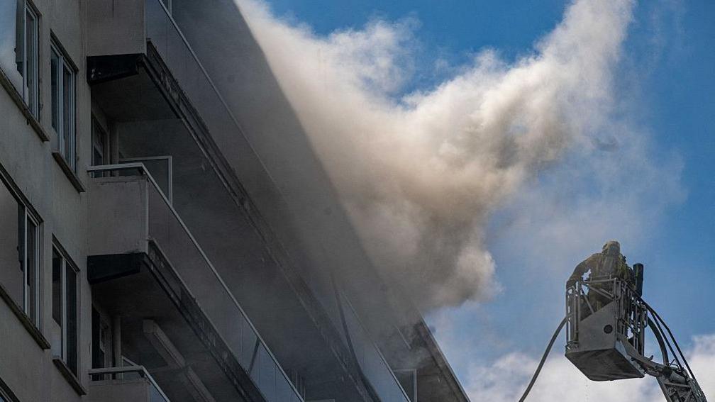 Firefighters at the scene of a fire in an apartment building in Antwerp