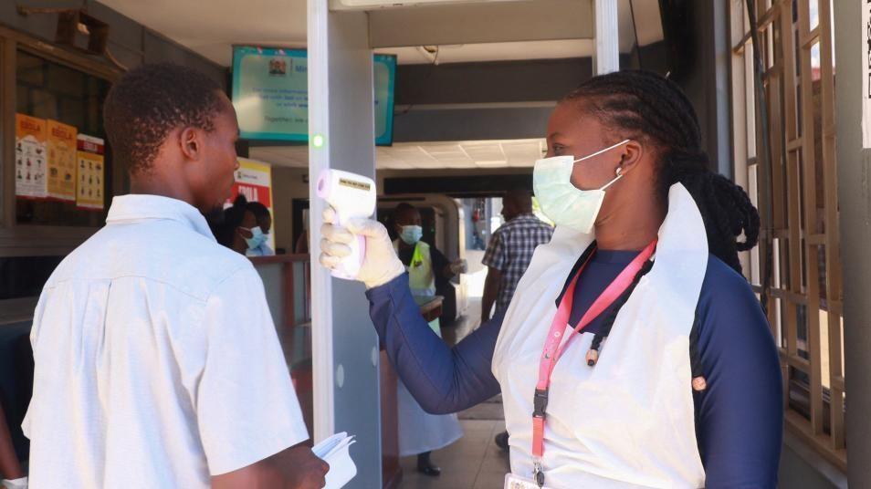 Medical worker checking traveller at Kenyan border