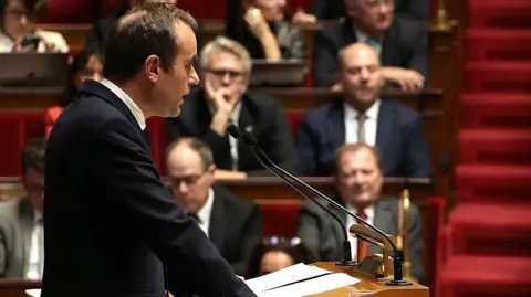 French PM Calls for Suspension of Macron's Pension Reforms to Preserve Government Stability
